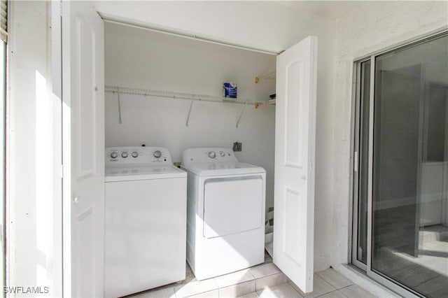 washroom with washer and dryer and light tile patterned floors