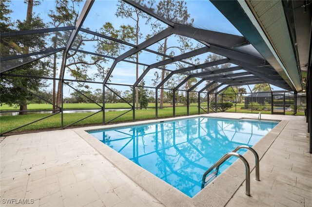 view of pool featuring a yard, glass enclosure, and a patio area