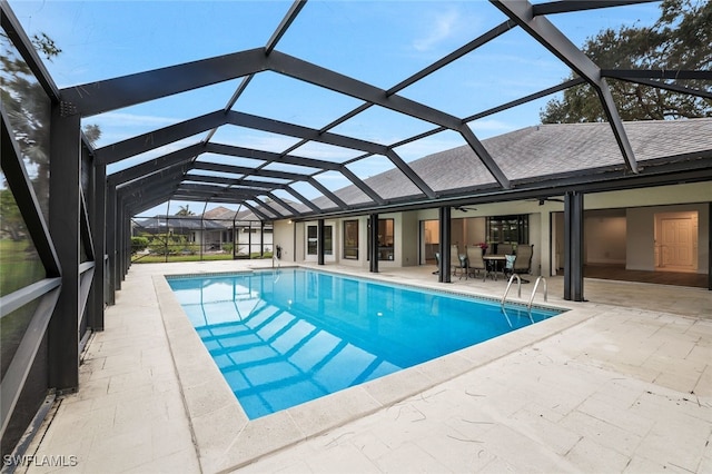 outdoor pool with a lanai, a ceiling fan, and a patio