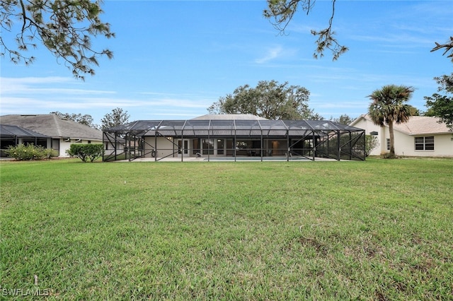 rear view of property with a lawn and a lanai