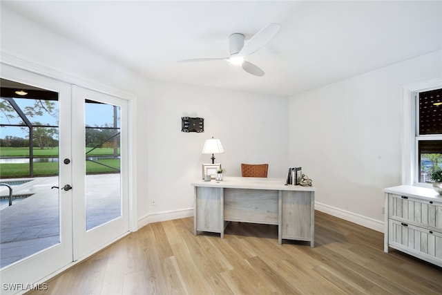 unfurnished office featuring baseboards, plenty of natural light, and light wood finished floors