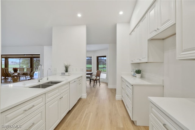 kitchen featuring light wood-style flooring, recessed lighting, a sink, light countertops, and dishwasher