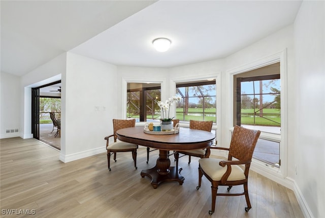 dining space with light wood-type flooring, visible vents, and baseboards