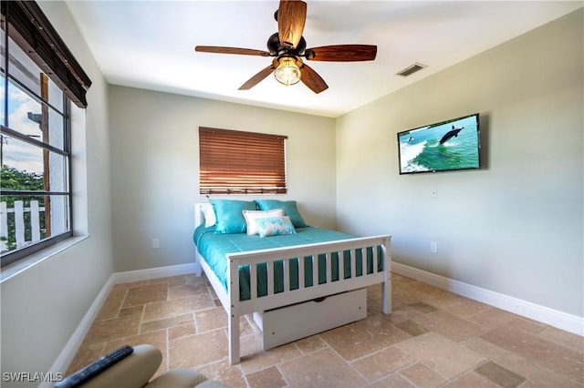 106 Pago Pago Dr W, Naples, FL 34113 - bedroom featuring stone tile flooring, baseboards, and a ceiling fan