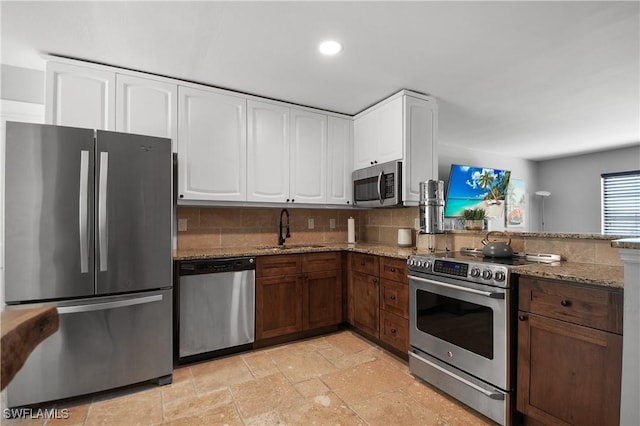 106 Pago Pago Dr W, Naples, FL 34113 - kitchen featuring stainless steel appliances, a sink, light stone countertops, white cabinetry, and recessed lighting
