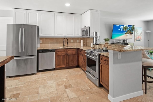 106 Pago Pago Dr W, Naples, FL 34113 - kitchen with stainless steel appliances, a sink, light stone counters, stone tile flooring, and recessed lighting