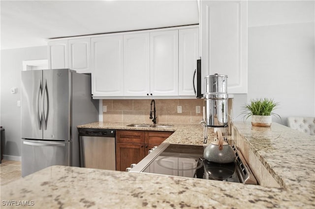 106 Pago Pago Dr W, Naples, FL 34113 - kitchen with appliances with stainless steel finishes, a sink, decorative backsplash, light stone countertops, and white cabinets