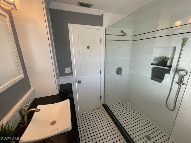 bathroom with a tile shower and sink