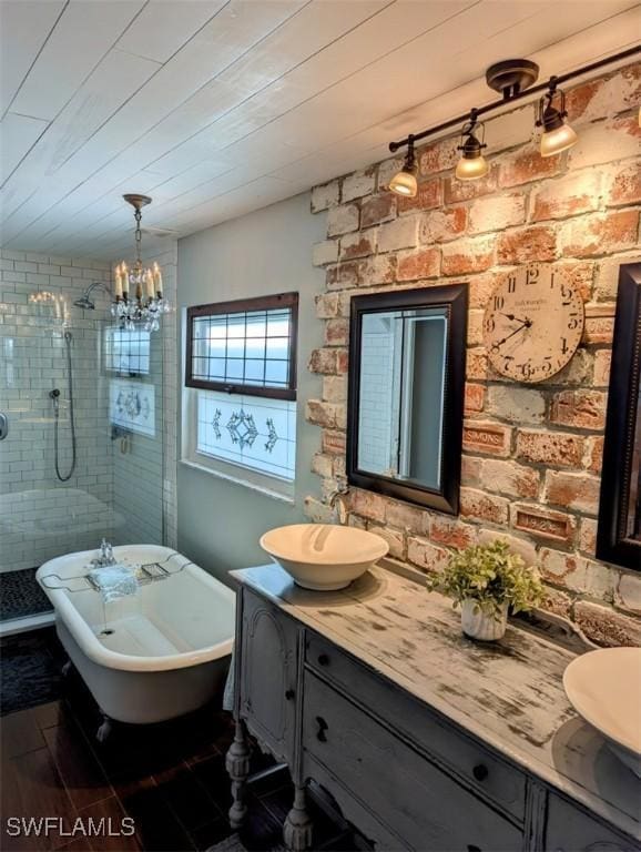 bathroom featuring plus walk in shower, brick wall, a notable chandelier, vanity, and hardwood / wood-style flooring