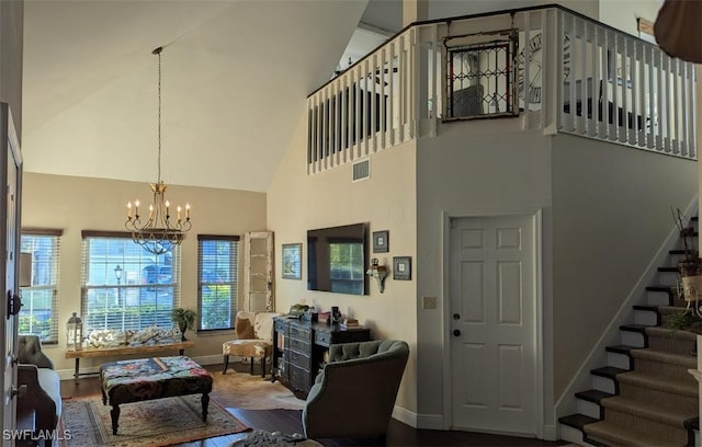 living room featuring wood-type flooring, high vaulted ceiling, and a notable chandelier