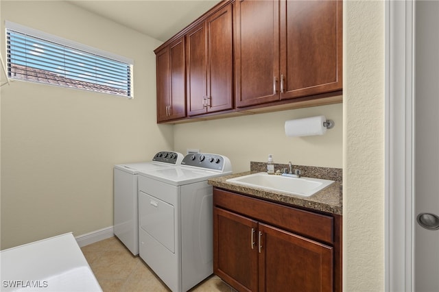 washroom featuring washer and clothes dryer, sink, light tile patterned floors, and cabinets