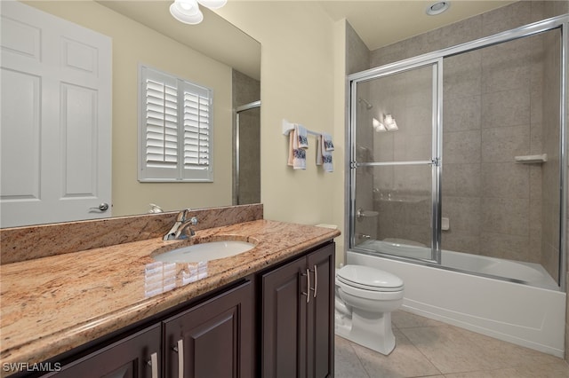 full bathroom with shower / bath combination with glass door, tile patterned flooring, vanity, and toilet