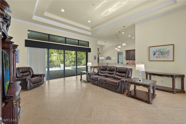 tiled living room with a high ceiling, a raised ceiling, and ornamental molding