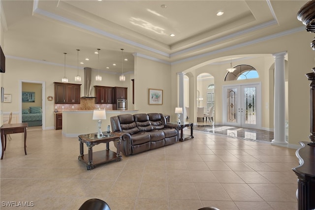 living room with ornamental molding, french doors, light tile patterned floors, and a tray ceiling