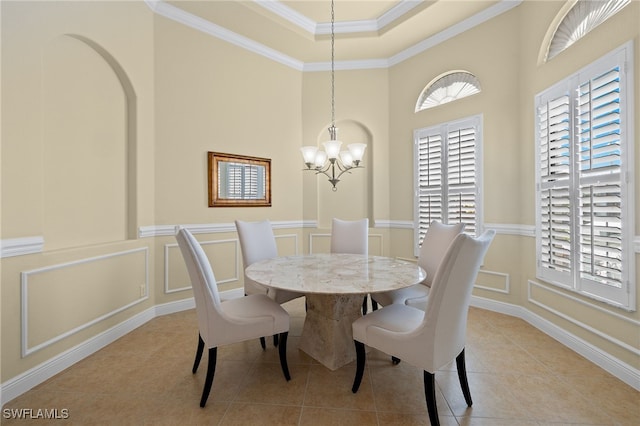 tiled dining space featuring ornamental molding and an inviting chandelier