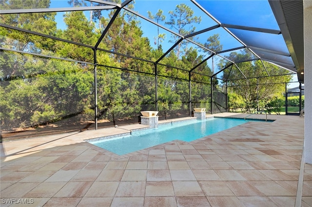 view of swimming pool with pool water feature, glass enclosure, and a patio area