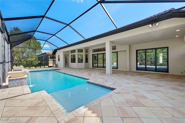 view of pool featuring glass enclosure, pool water feature, and a patio