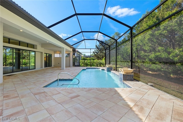 view of pool with pool water feature, a lanai, and a patio