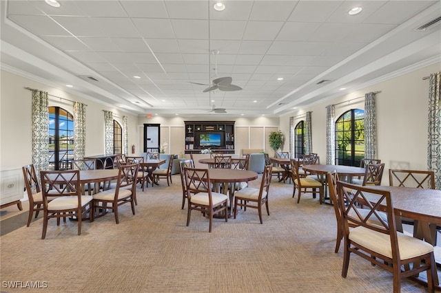 dining space with crown molding, a wealth of natural light, and light carpet