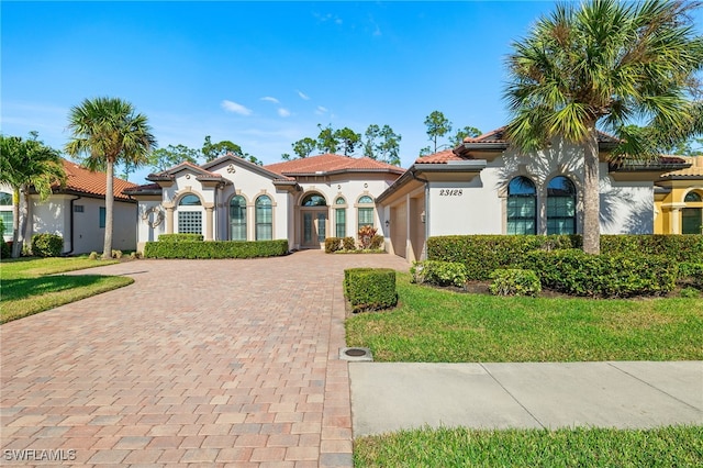 mediterranean / spanish house featuring a front yard and a garage