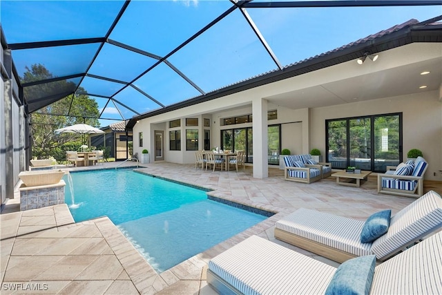 view of swimming pool with an outdoor living space, glass enclosure, pool water feature, and a patio area