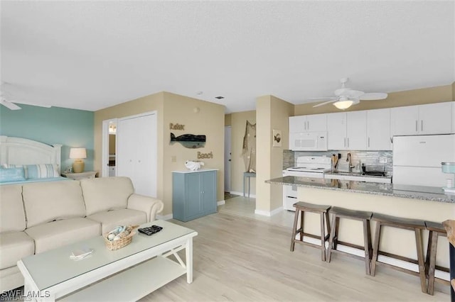 living room with ceiling fan, light wood-type flooring, and sink