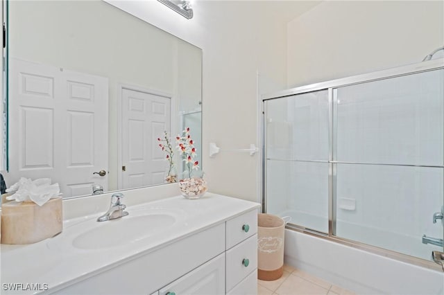 bathroom with tile patterned floors, vanity, and combined bath / shower with glass door