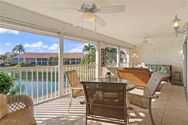 sunroom / solarium with a water view and ceiling fan