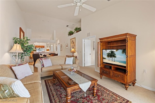 carpeted living room with high vaulted ceiling and ceiling fan