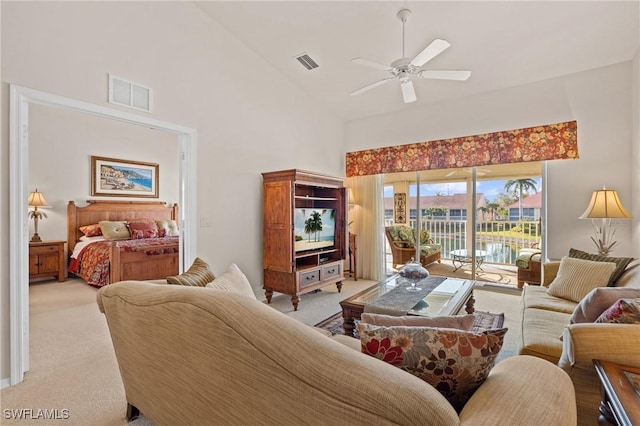 carpeted living room with ceiling fan and high vaulted ceiling