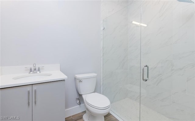 bathroom featuring vanity, toilet, wood-type flooring, and a shower with shower door