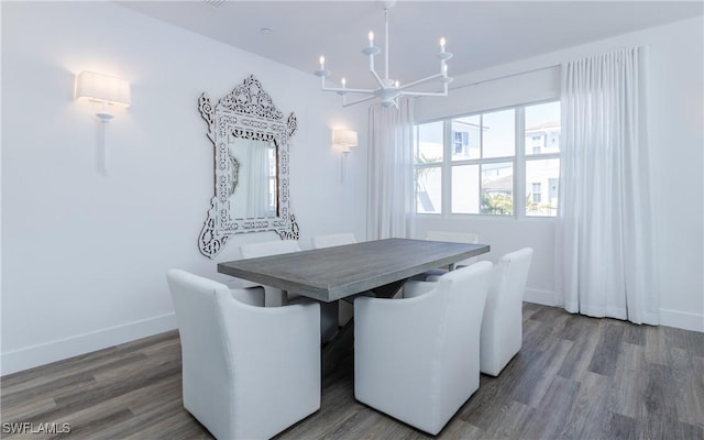 dining area featuring dark hardwood / wood-style flooring and an inviting chandelier