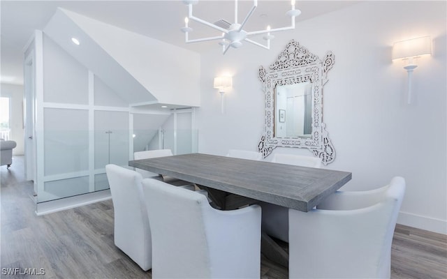 dining room featuring high vaulted ceiling, light hardwood / wood-style floors, and an inviting chandelier