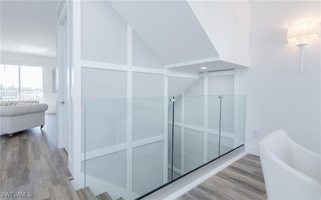 bathroom featuring hardwood / wood-style flooring and vaulted ceiling