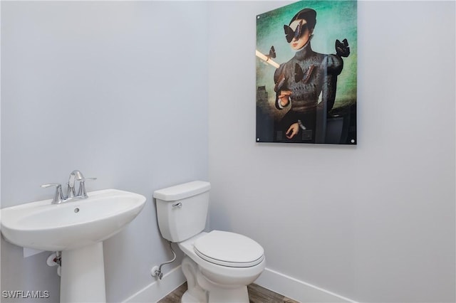 bathroom with hardwood / wood-style flooring, toilet, and sink