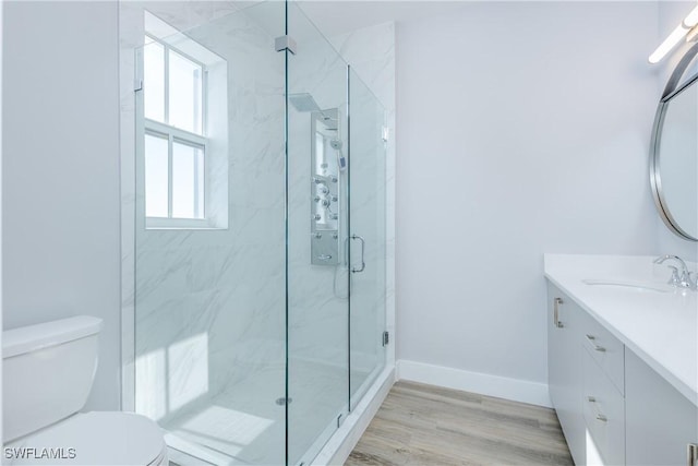 bathroom featuring hardwood / wood-style flooring, vanity, toilet, and a shower with shower door