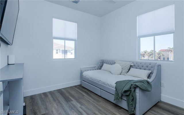 bedroom featuring multiple windows and dark hardwood / wood-style floors