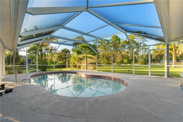 view of pool featuring a lawn, glass enclosure, and a patio area