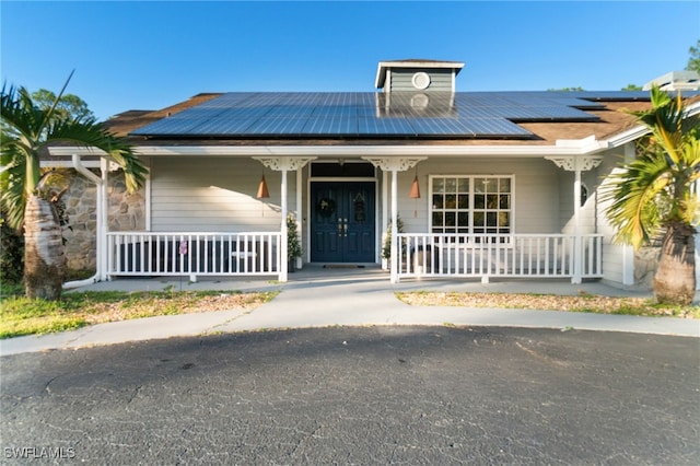 view of front facade featuring covered porch and solar panels