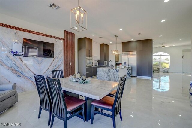 dining space with ceiling fan with notable chandelier