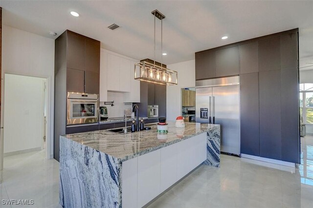 kitchen with white cabinetry, a large island, sink, stainless steel appliances, and pendant lighting