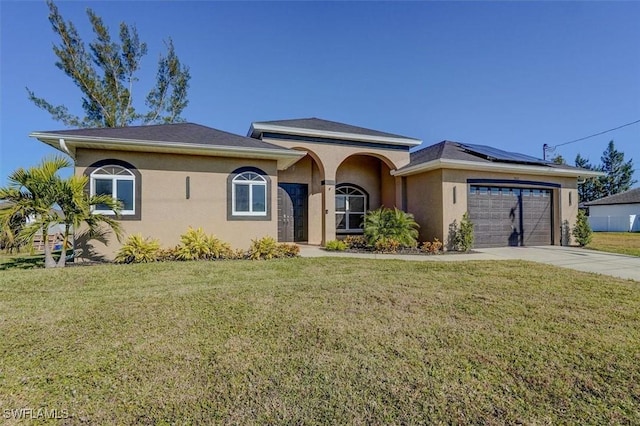 view of front of home with a front lawn, a garage, and solar panels