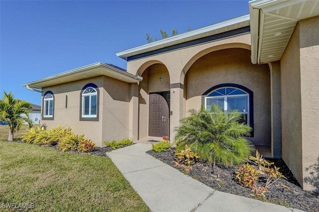 property entrance with a lawn