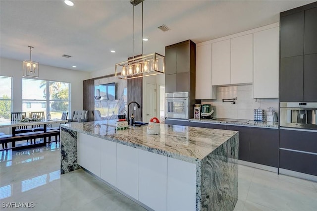 kitchen featuring a spacious island, oven, and hanging light fixtures