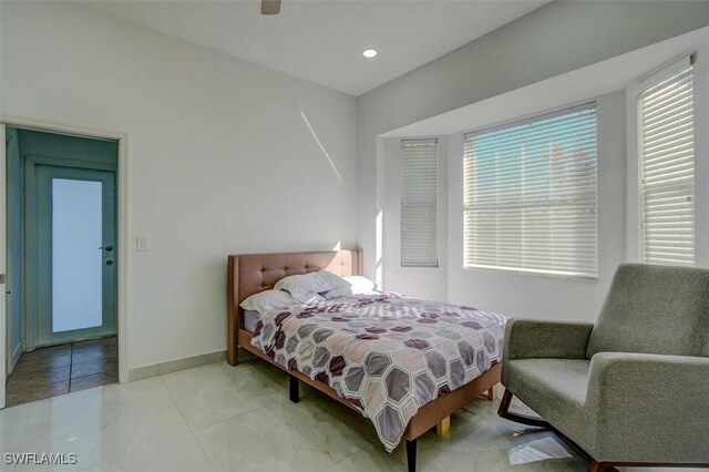 tiled bedroom featuring ceiling fan