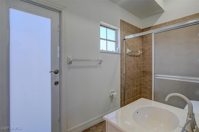 bathroom featuring an enclosed shower and sink