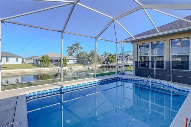 view of swimming pool with glass enclosure and a water view