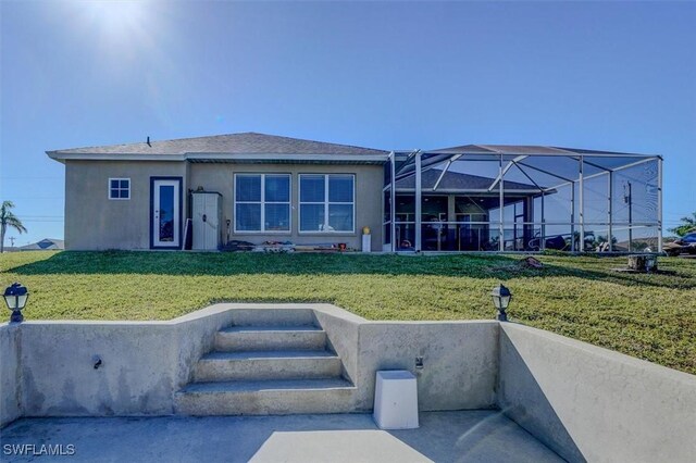 rear view of property with a lanai and a yard