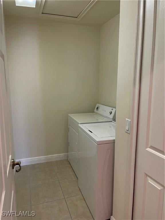 laundry room with washer and clothes dryer and light tile patterned floors