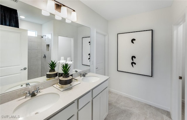 bathroom with a tile shower and vanity